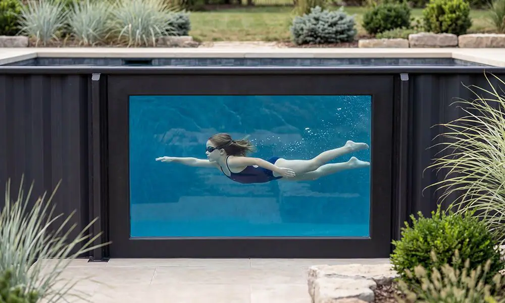 Girl swimming in Ecopool container pool with acrylic window