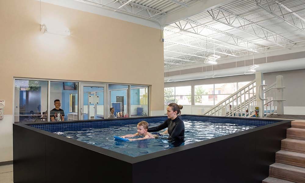 Instructor teaching swim lesson in Ecopool