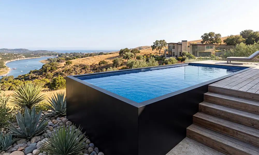 Above ground pool with decking and modern landscaping at sunset